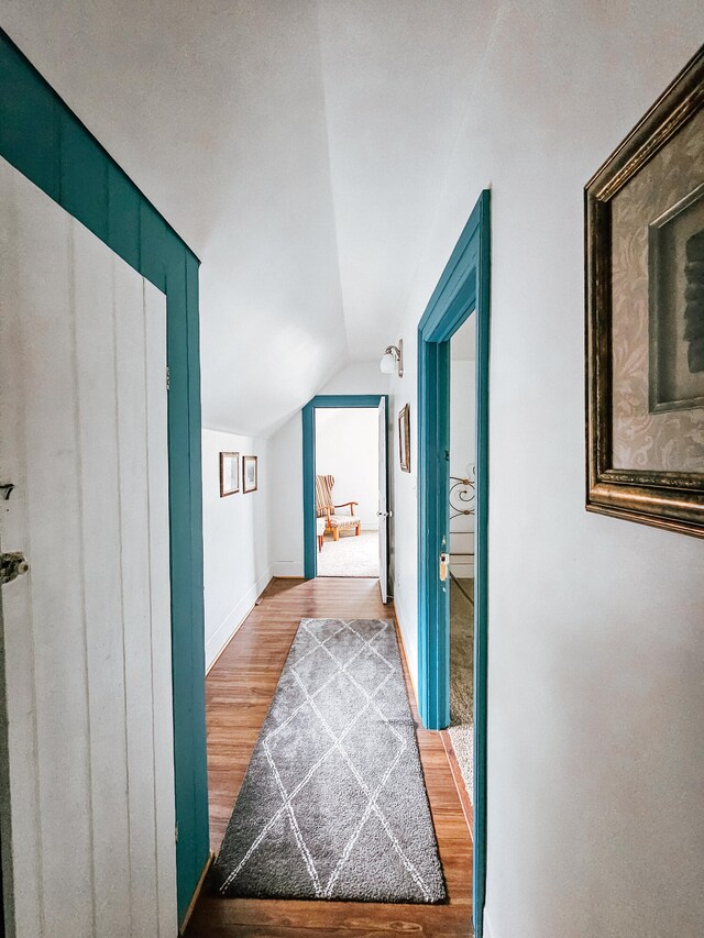 corridor featuring hardwood / wood-style floors and vaulted ceiling