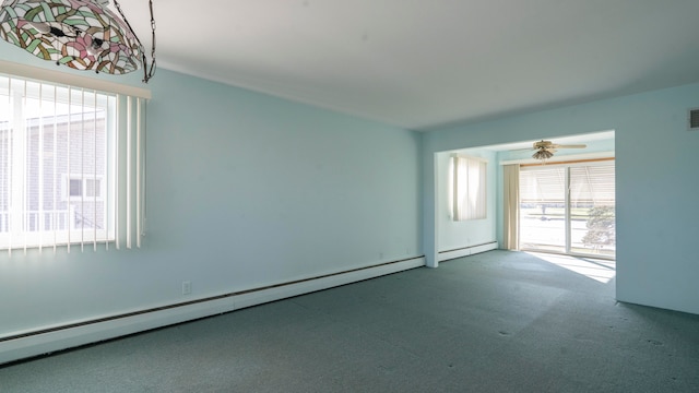 spare room featuring a baseboard radiator, carpet floors, and a healthy amount of sunlight