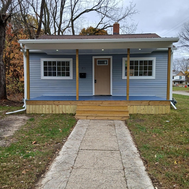 bungalow featuring a porch and a front lawn