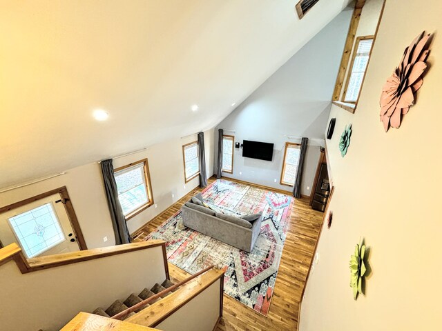 living room featuring high vaulted ceiling and light wood-type flooring