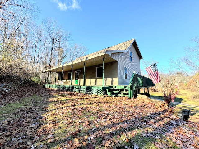 view of side of home featuring covered porch