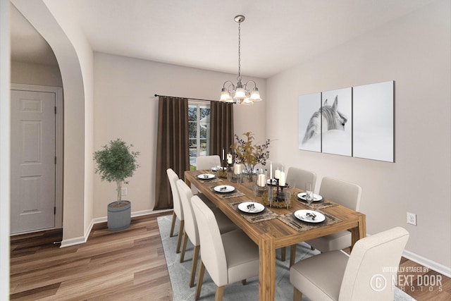 dining room featuring vaulted ceiling, wood-type flooring, and a chandelier