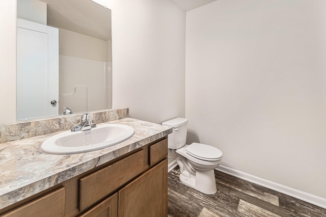 bathroom featuring vanity, toilet, wood-type flooring, and a shower