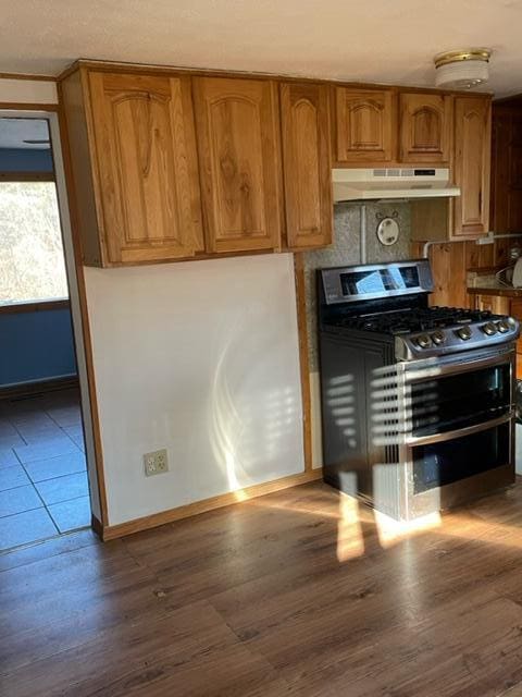 kitchen with black gas range oven and dark hardwood / wood-style floors