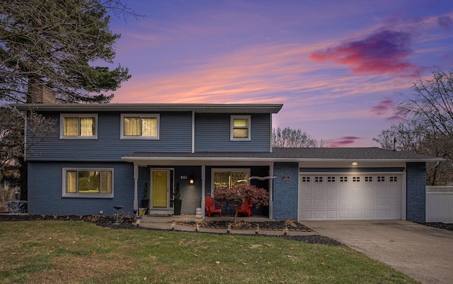 front facade with a garage, a yard, and a porch