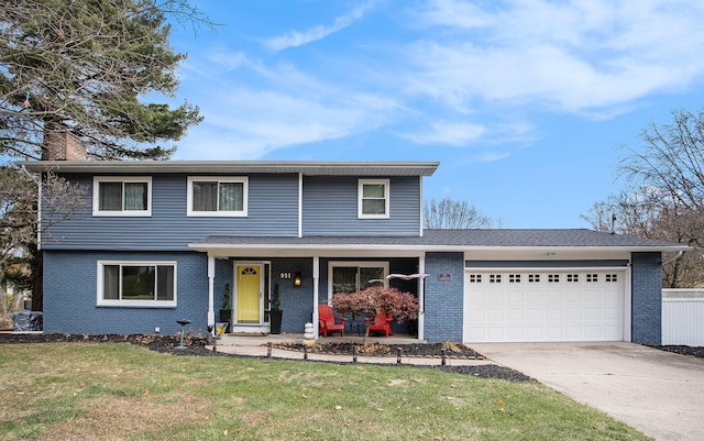 view of property featuring a garage, a front lawn, and covered porch