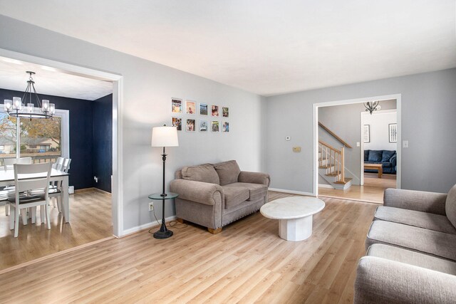 living room featuring a chandelier and light hardwood / wood-style flooring