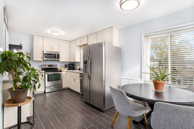 kitchen featuring white cabinets, dark hardwood / wood-style flooring, and appliances with stainless steel finishes