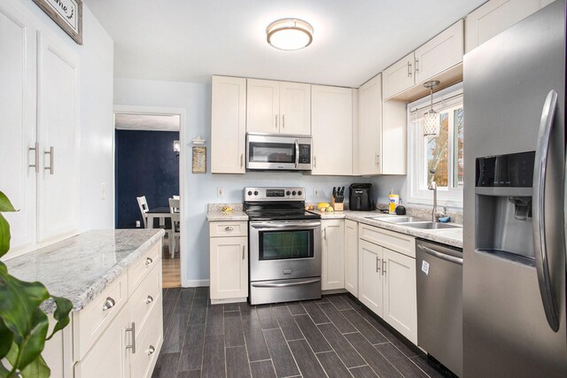 kitchen with white cabinetry, appliances with stainless steel finishes, and dark hardwood / wood-style floors