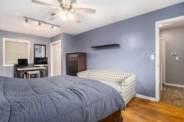 bedroom with ceiling fan, wood-type flooring, and rail lighting