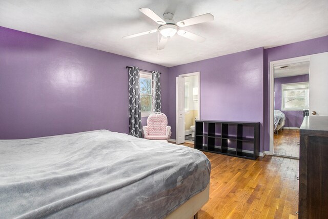 bedroom featuring hardwood / wood-style floors, ensuite bathroom, and ceiling fan