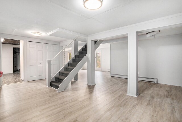 basement featuring a baseboard radiator and wood-type flooring