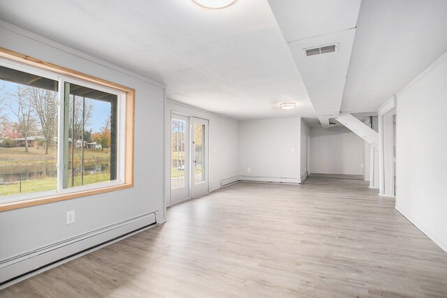 spare room with a baseboard radiator and light wood-type flooring