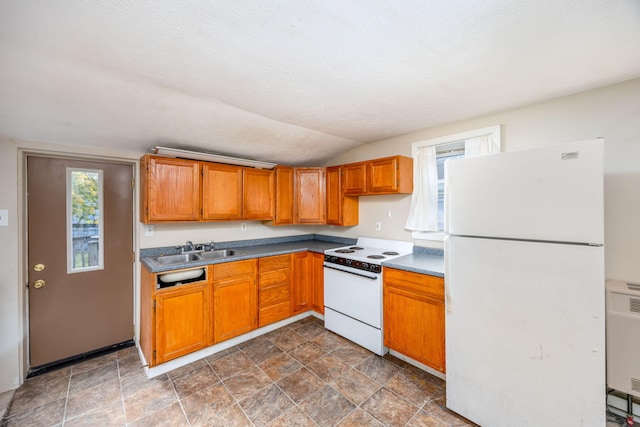 kitchen featuring a textured ceiling, sink, white appliances, and vaulted ceiling