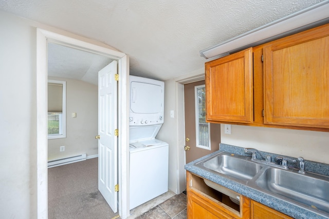 kitchen featuring a wealth of natural light, baseboard heating, sink, and vaulted ceiling