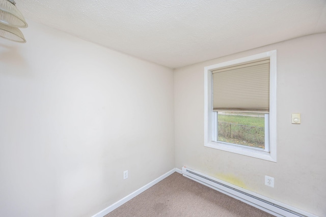 carpeted spare room with baseboard heating and a textured ceiling