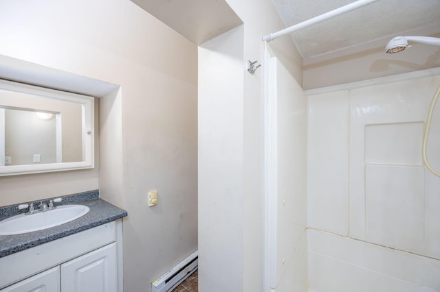 bathroom featuring walk in shower, vanity, and a baseboard heating unit