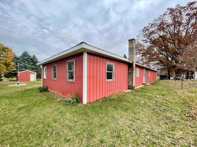 view of side of property featuring a lawn and a shed