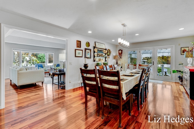 dining room featuring a notable chandelier, light hardwood / wood-style floors, and plenty of natural light