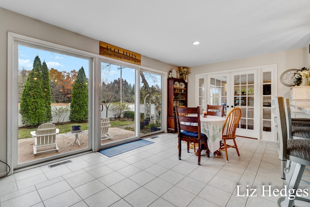 dining area with a wealth of natural light, french doors, and light tile patterned flooring