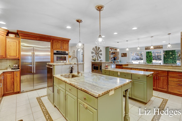 kitchen featuring hanging light fixtures, stainless steel appliances, and a kitchen island with sink