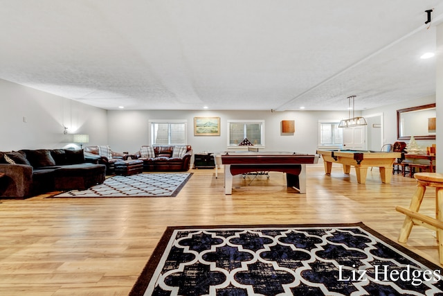 game room with wood-type flooring, billiards, and a textured ceiling