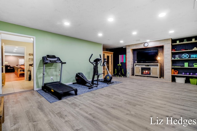 exercise room with built in features and light hardwood / wood-style flooring