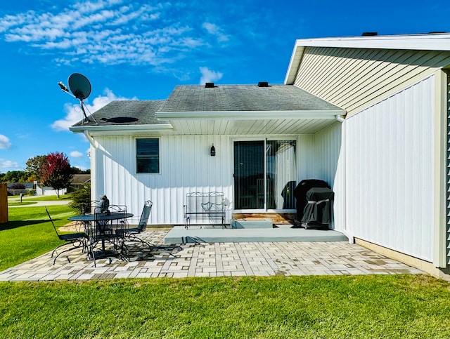 rear view of property featuring a yard and a patio area