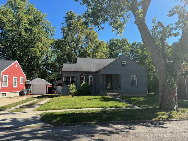 view of front of house with a front lawn, a garage, and an outbuilding