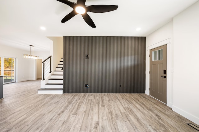 unfurnished living room featuring ceiling fan and light hardwood / wood-style flooring