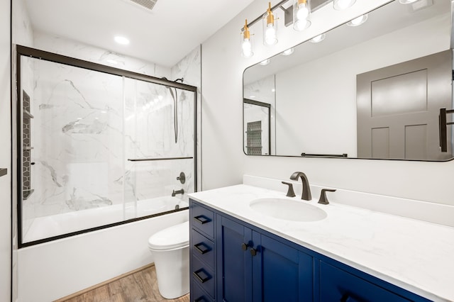 full bathroom featuring wood-type flooring, vanity, toilet, and enclosed tub / shower combo