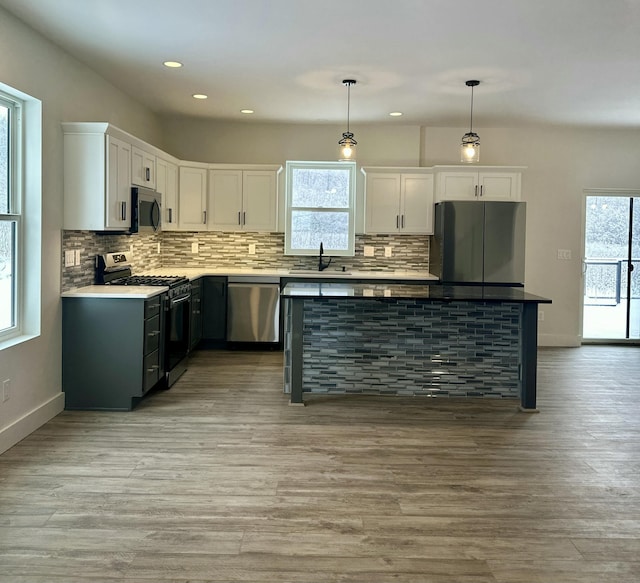 kitchen with a wealth of natural light, white cabinets, and appliances with stainless steel finishes