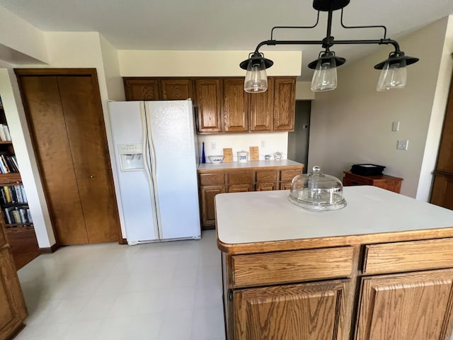 212 Saint Anne Ln, Monroe, MI 48162 - kitchen with white fridge with ice dispenser, light countertops, a center island, and brown cabinets