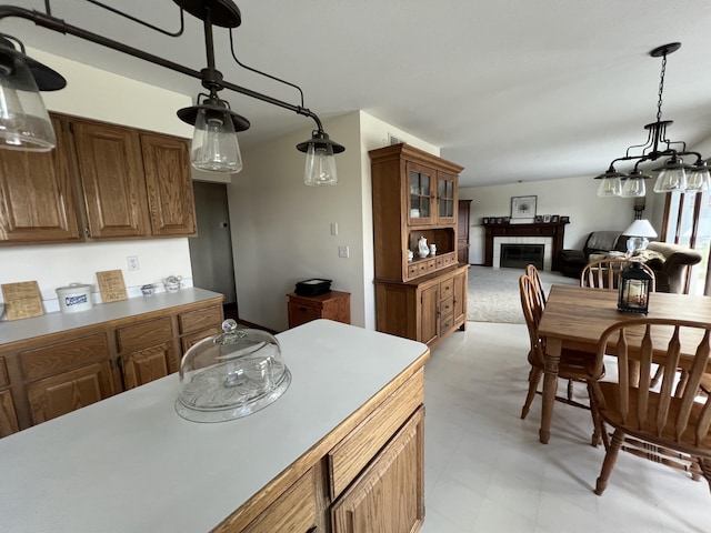 212 Saint Anne Ln, Monroe, MI 48162 - kitchen featuring a fireplace, brown cabinets, glass insert cabinets, and decorative light fixtures