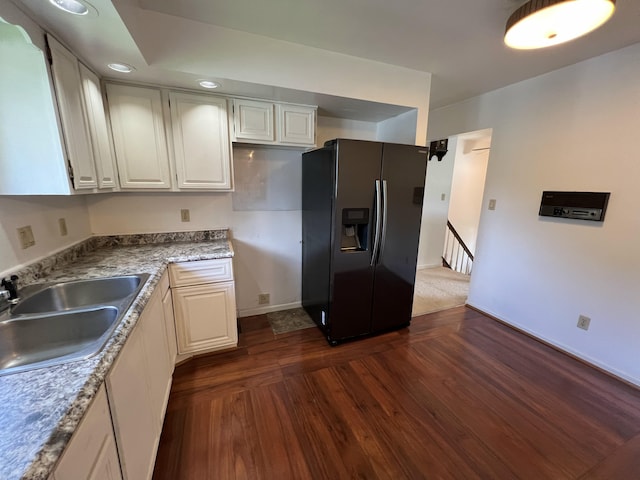 kitchen featuring dark hardwood / wood-style flooring, white cabinetry, sink, and black fridge with ice dispenser