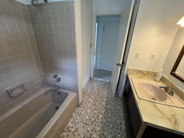 bathroom with tiled shower / bath combo, vanity, and tile patterned flooring