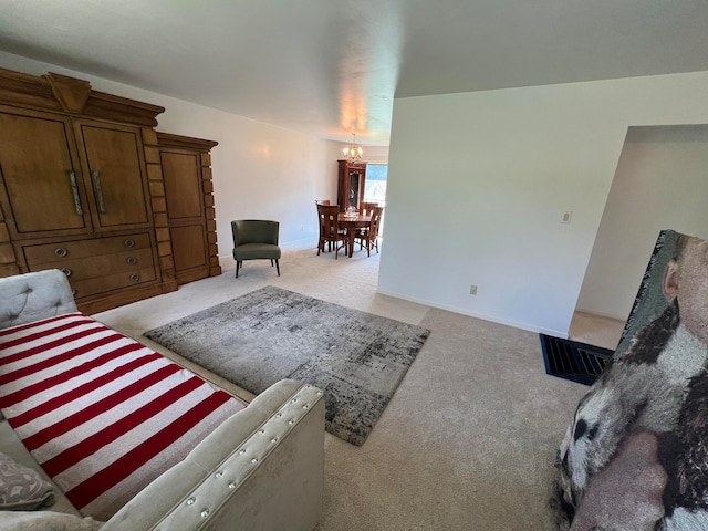 unfurnished living room featuring a chandelier and light carpet