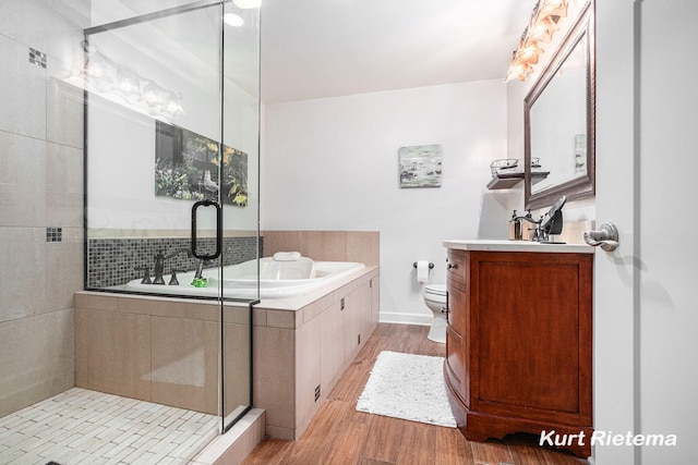 full bathroom with hardwood / wood-style floors, vanity, toilet, and separate shower and tub