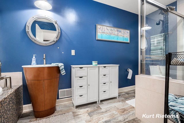 bathroom featuring an enclosed shower, vanity, and hardwood / wood-style flooring