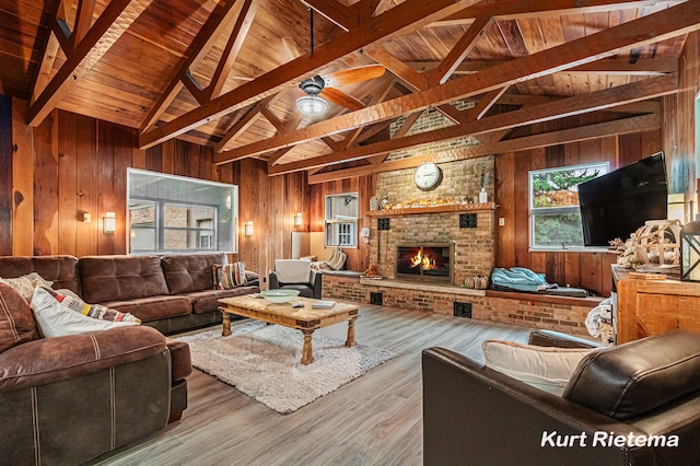 living room featuring lofted ceiling with beams, wood walls, wood ceiling, hardwood / wood-style floors, and a brick fireplace