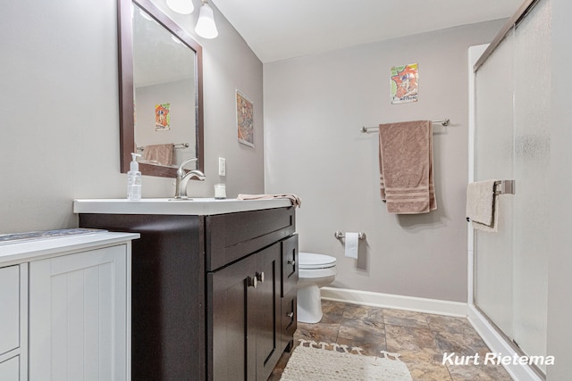 bathroom featuring toilet, vanity, and an enclosed shower