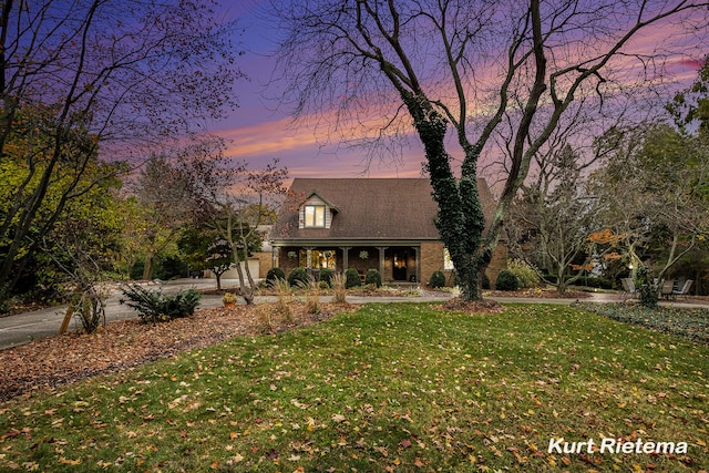 new england style home with a yard and a porch