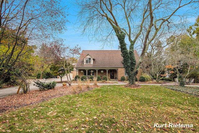 new england style home with a porch and a front lawn