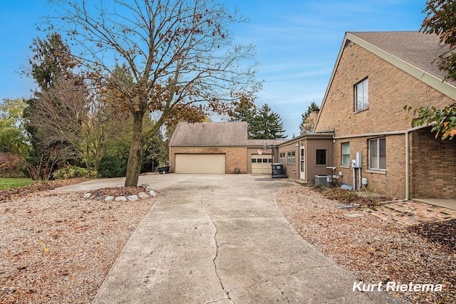 view of side of property featuring a garage and central AC unit