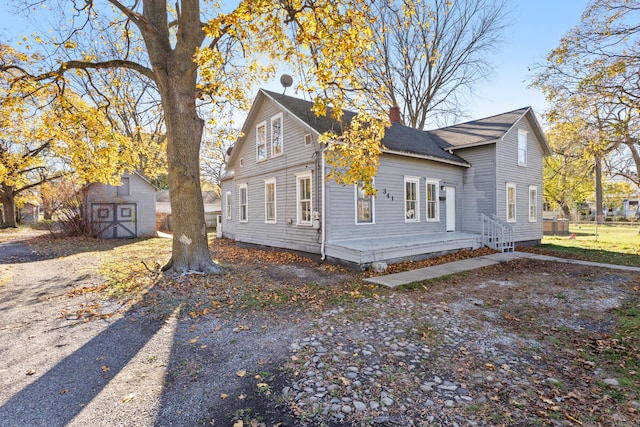 view of front of home featuring a deck and a storage shed