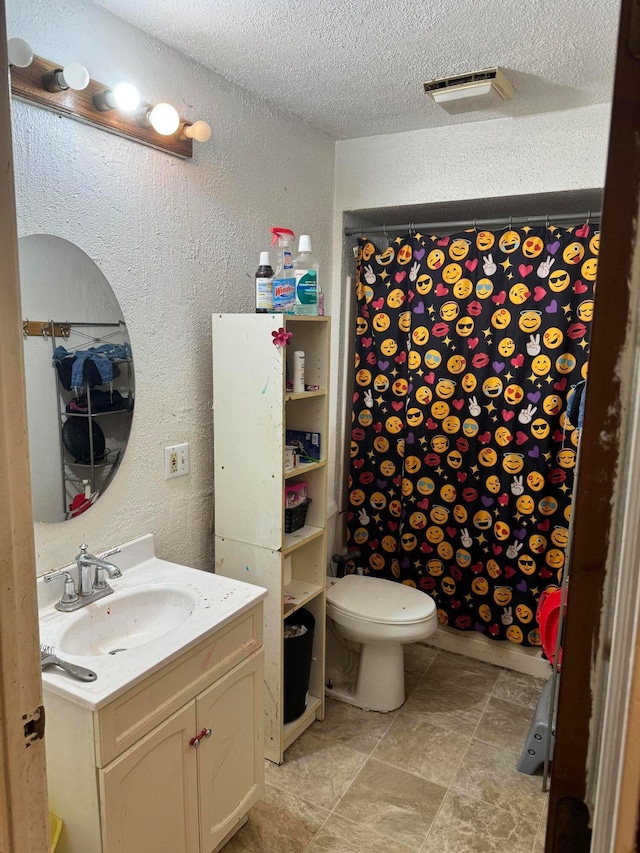 bathroom featuring toilet, a shower with curtain, vanity, and a textured ceiling