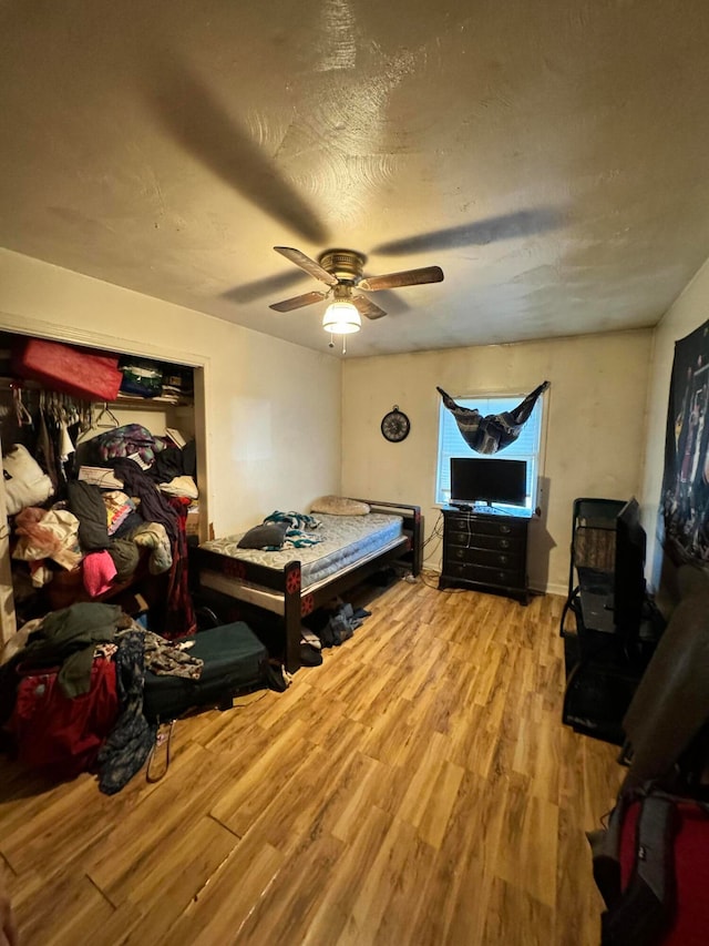 bedroom featuring ceiling fan, a textured ceiling, and wood-type flooring