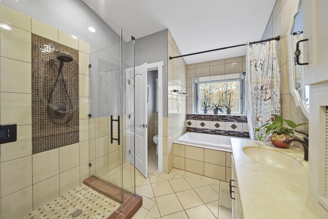 full bathroom featuring tile patterned flooring, shower with separate bathtub, vanity, and toilet