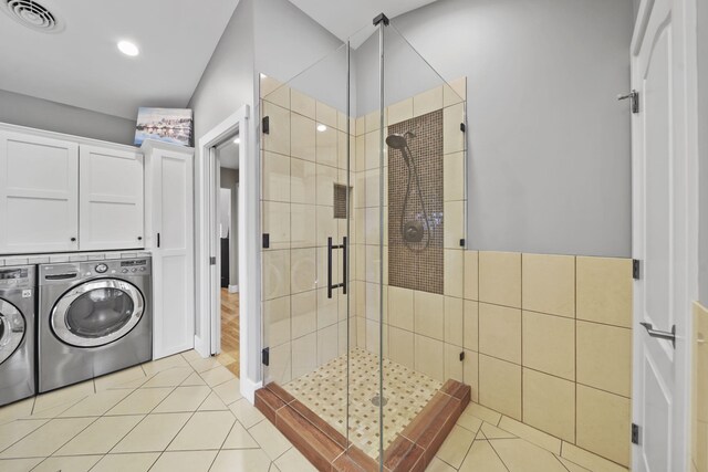 bathroom with tile patterned floors, walk in shower, and washing machine and clothes dryer