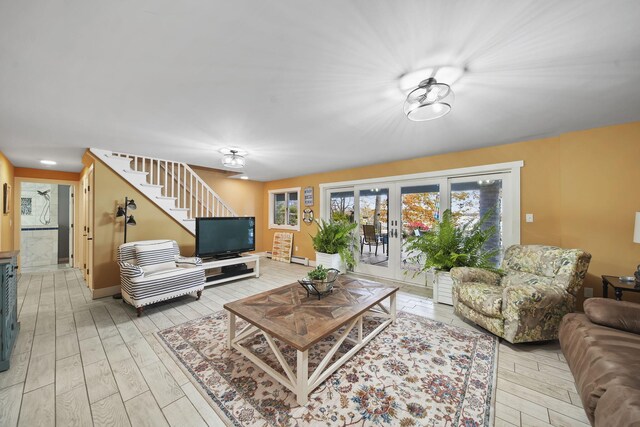 living room featuring french doors, light hardwood / wood-style floors, and a baseboard radiator